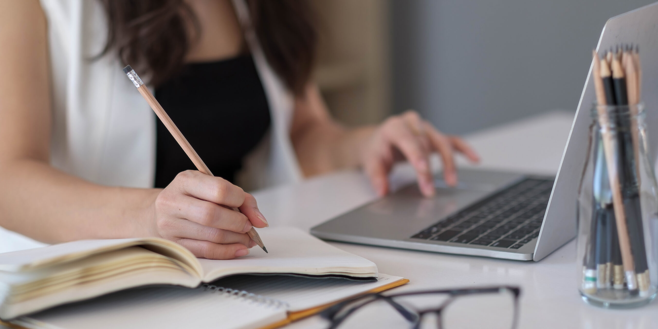Closeup banner asian woman writing on notebook on table with laptop, girl work at coffee shop, freelance business concept.